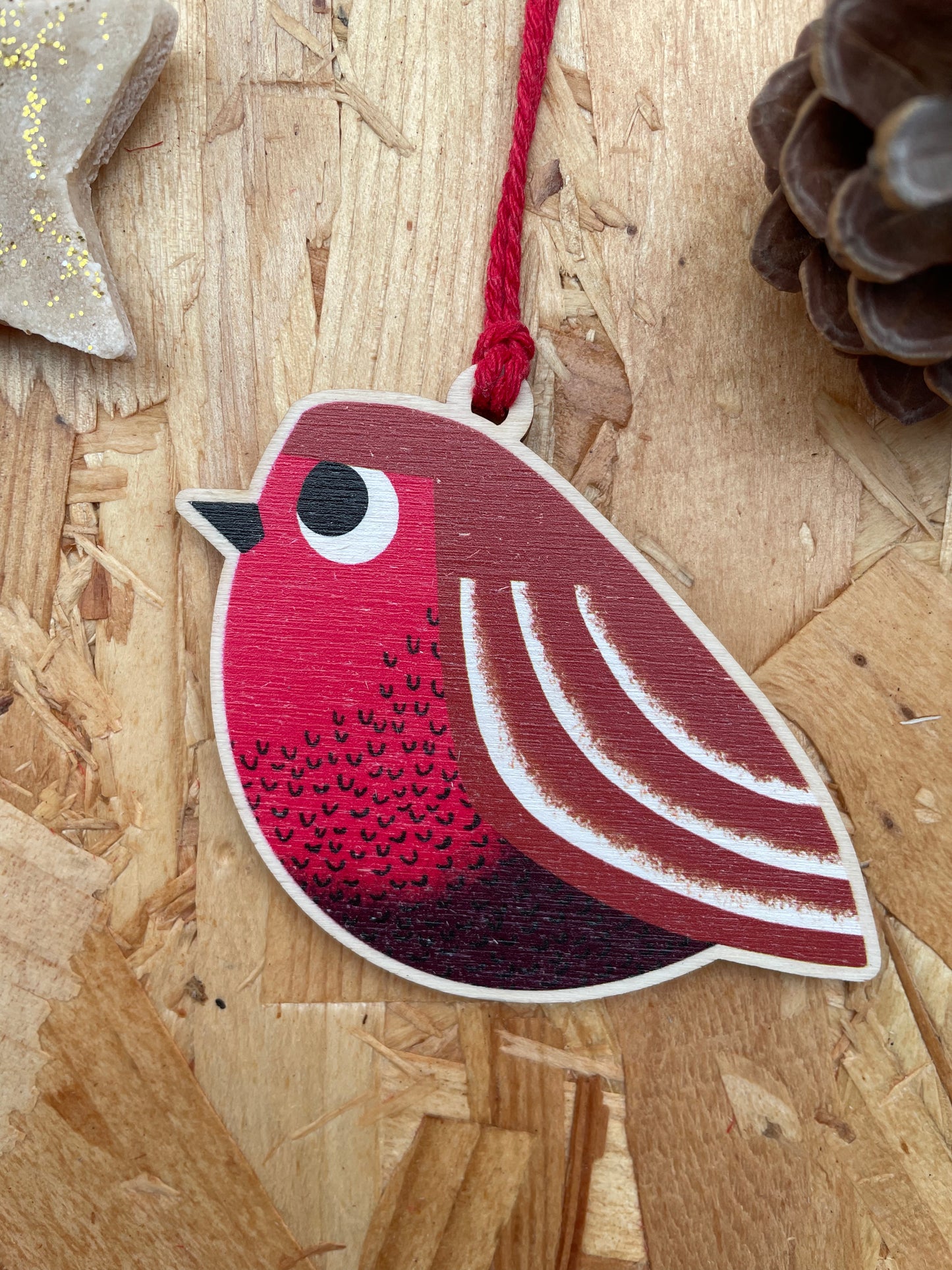 Decorative red bird ornament on a wooden surface