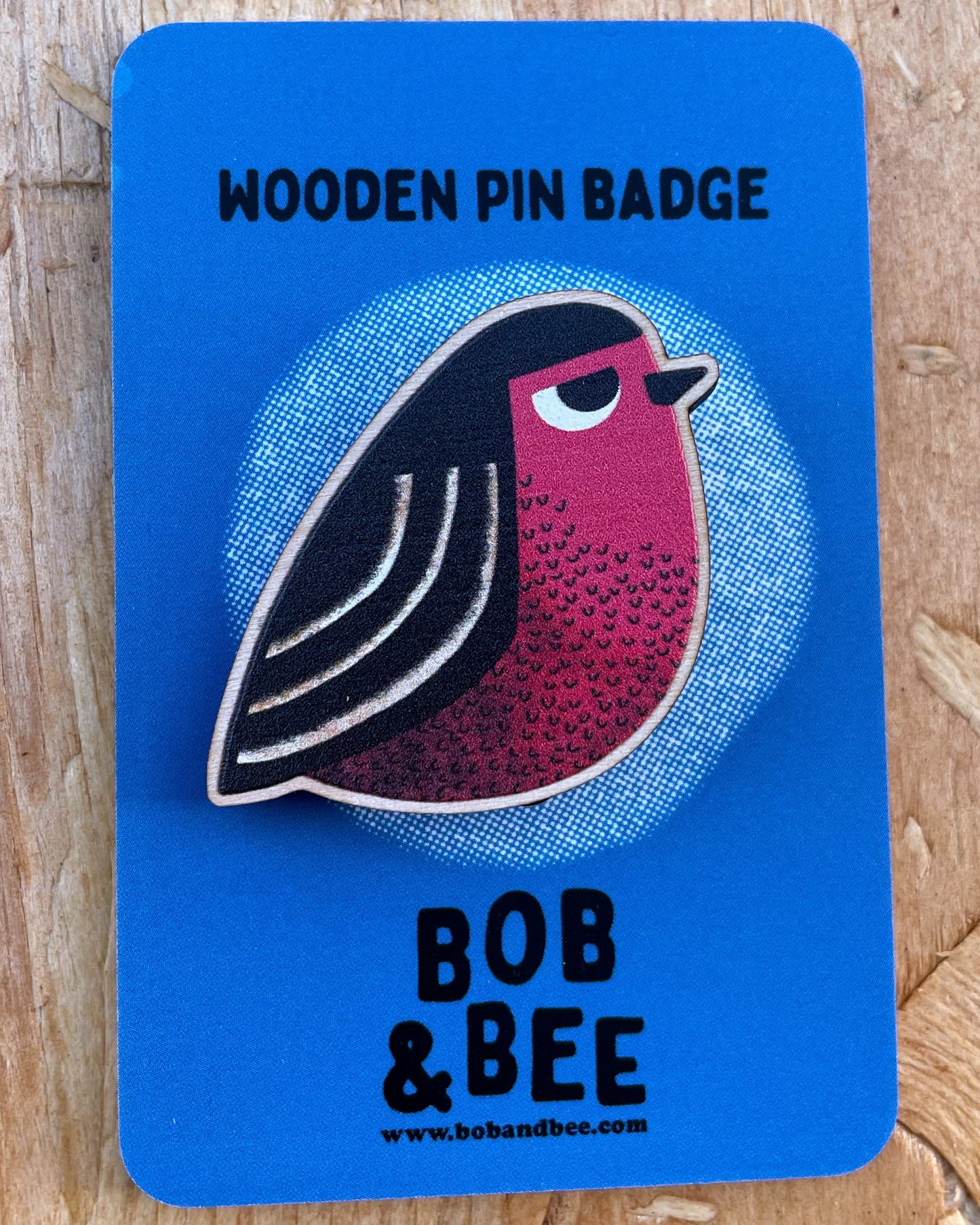 Wooden pin badge with a robin bird design on a blue card, featuring the brand 'Bob & Bee'.