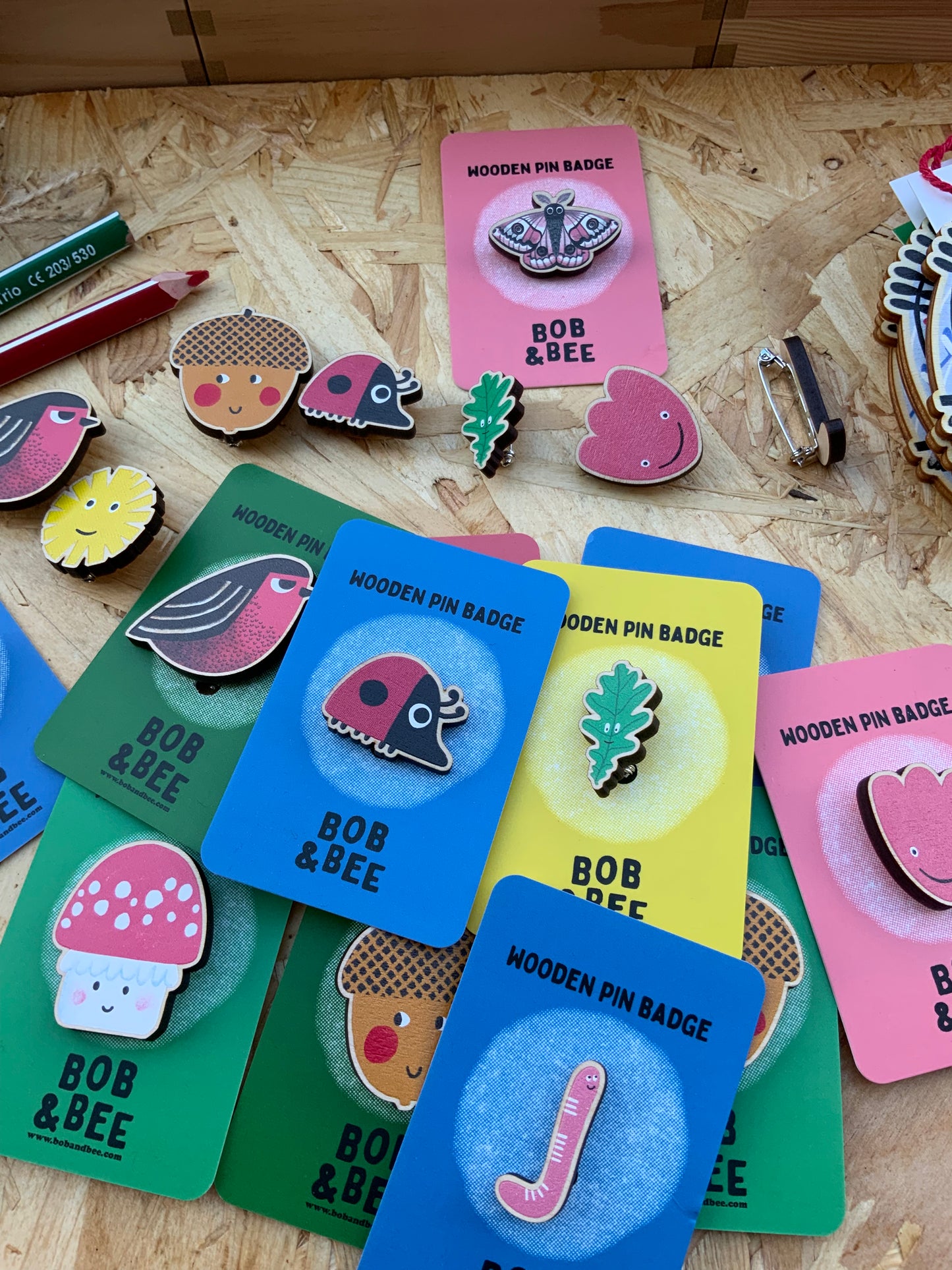Collection of colorful wooden pin badges on a wooden surface